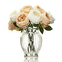 a clear glass vase filled with white and pink roses