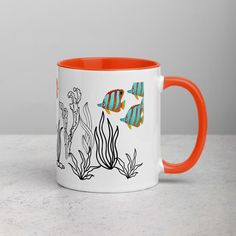 an orange and white coffee mug with fish on it