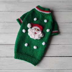 a green sweater with a santa clause on it