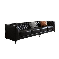 a black leather couch with two pillows on it