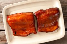 two pieces of cooked fish on a white plate