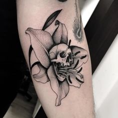 a skull and flower tattoo on the arm