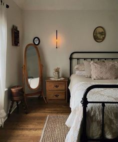 a bed room with a neatly made bed and a mirror