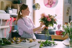 a woman is arranging flowers in her kitchen