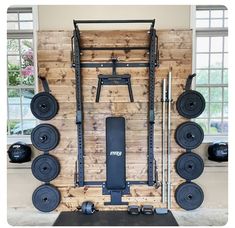 a home gym with squats, barbells and weight plates on the wall