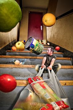 a man is sitting on the steps with bags full of food in front of him