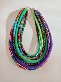 Lovely colors green and purple are featured in this multistrand Tribal necklace. All sewn and designed by me. I have also used African print fabric on some of the cords. Super light weight necklace. to view the bracelets and bangle  https://www.etsy.com/shop/nad205?ref=listing-shop2-all-items-count&section_id=13626749 length of necklace from one end to the other layed down in a straight line is 20 inches or 50 cm. I also added 3 inch extension chain  Care: This is a fabric necklace so a minimum Multicolor Handmade Multi-strand Layered Necklace, Cheap Green Multi-strand Necklaces, Green Multi-strand Hand-strung Necklaces, Green Multi-strand Necklace With Colorful Beads, Multicolor Large Beads Multi-strand Necklace, Dry Cleaning At Home, African Necklace, Fabric Necklace, Chunky Jewelry