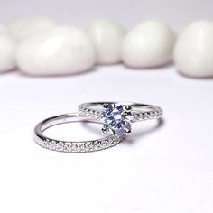 a diamond ring sitting on top of a white surface