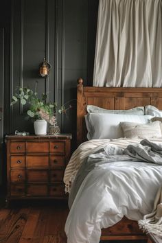 a bed with white sheets and pillows in a bedroom next to a dresser, lamp and window