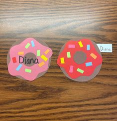 two paper donuts with different colored sprinkles and the word diana on them