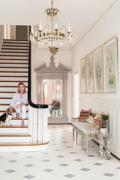 a woman is sitting on the stairs with her dog