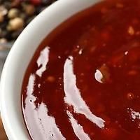 a white bowl filled with red sauce next to beans