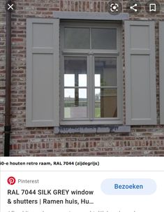 an image of a window with shutters on the side of a brick building that has white trim