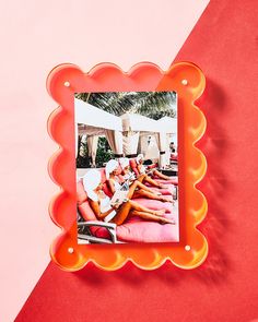 an orange and pink frame with a woman laying on it