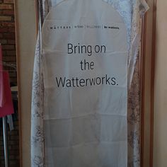 a white sign hanging on the side of a door that says, bring on the water works