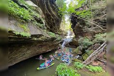 several canoes are in the water near some cliffs