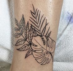 a tattoo on the leg of a woman with leaves and an apple in the center