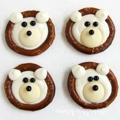 four decorated cookies with white frosting and brown teddy bears on them are arranged in the shape of circles