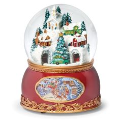 a snow globe with a christmas scene in it on top of a red base and gold trimming