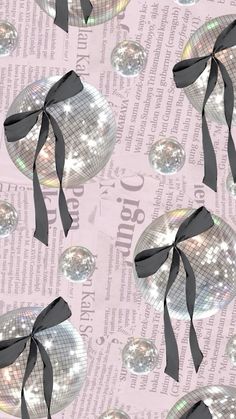 disco balls with black ribbons on a pink background