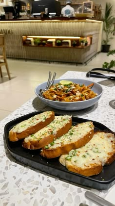 two plates of food on a table with utensils and silverware in the background