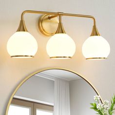 a bathroom vanity light with three lights on the side and a mirror in front of it