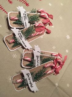 three candy canes are wrapped in paper and tied with ribbon