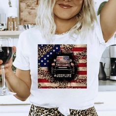 a woman holding a glass of wine in front of an american flag t - shirt