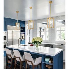 a kitchen with blue cabinets and white counter tops, gold chandelier hanging from the ceiling