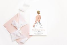 a wedding card with the bride's dress drawn on it next to a pink envelope