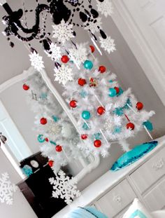 a white christmas tree with red and blue ornaments