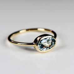 14k Solid gold east west oval aquamarine ring. It made of 14k solid yellow gold band and 7x5mm faceted cut oval aquamarine stone in 14k yellow gold bezel setting. DETAILS ABOUT THE RING, MATERIAL AND STONESRing Band: 14K YELLOW GOLDRing Band size: 1.2mm round.Gemstone: Oval aquamarineAquamarine size: 7x5mm oval cut.Setting Type : Bezel setting ABOUT AQUAMARINEAquamarine is a symbol of beauty, honesty, and loyalty. March birthstone. Aquamarine is the anniversary gemstone for the 16th and 19th yea Oval Aquamarine Ring, Ultrasonic Jewelry Cleaner, Topaz Jewelry, Tourmaline Jewelry, Bristle Brush, Aquamarine Jewelry, Aquamarine Ring, Garnet Jewelry, March Birthstone