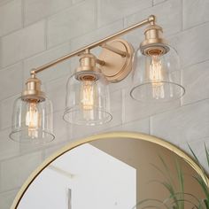 a bathroom vanity light with three clear glass shades