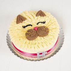 a cake decorated to look like a cat with brown eyes and whiskers on it