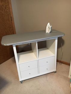 an ironing board on top of a white cabinet