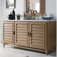 a bathroom vanity with wooden shutters and a large mirror above it, in front of a white brick wall