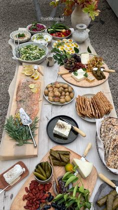 a table full of different types of food on plates and serving platters with cheeses