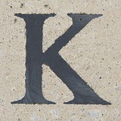 the letter k is painted on concrete with black paint