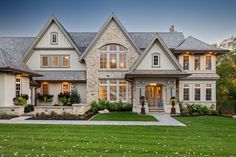 a large white house with lots of windows and grass in front of the door area