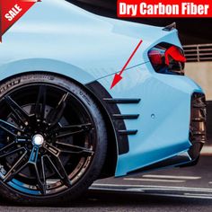 the front end of a blue sports car with an arrow pointing to dry carbon fiber