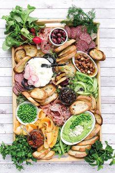 a platter filled with meats, bread and veggies