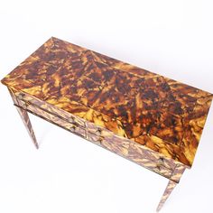 an old wooden table with two drawers on one side and gold leaf design on the other