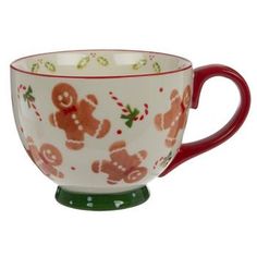 a red and white coffee cup with gingerbreads on the inside is sitting in front of a white background