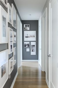 a long hallway with pictures on the wall and wooden flooring in front of it