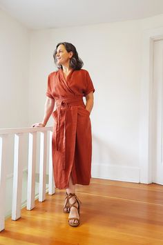 a woman in an orange dress is standing on the stairs