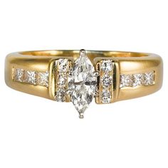 a yellow gold engagement ring with an oval cut diamond surrounded by smaller round brilliant diamonds