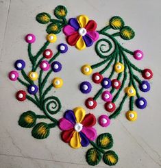 a colorful floral design on the floor is made with felt and beads, along with other decorative items