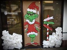 the grinch door is decorated with toilet paper and christmas signs in front of it