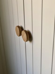 three wooden knobs are mounted on the wall