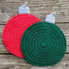 two crocheted christmas ornaments sitting on top of a wooden table